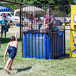 A child throwing a ball at a dunk tank, illustrating how this fundraising idea works.