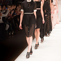 Models walking down a catwalk, participating in a fashion show.