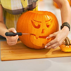 Someone carving a pumpkin as part of a pumpkin carving contest.